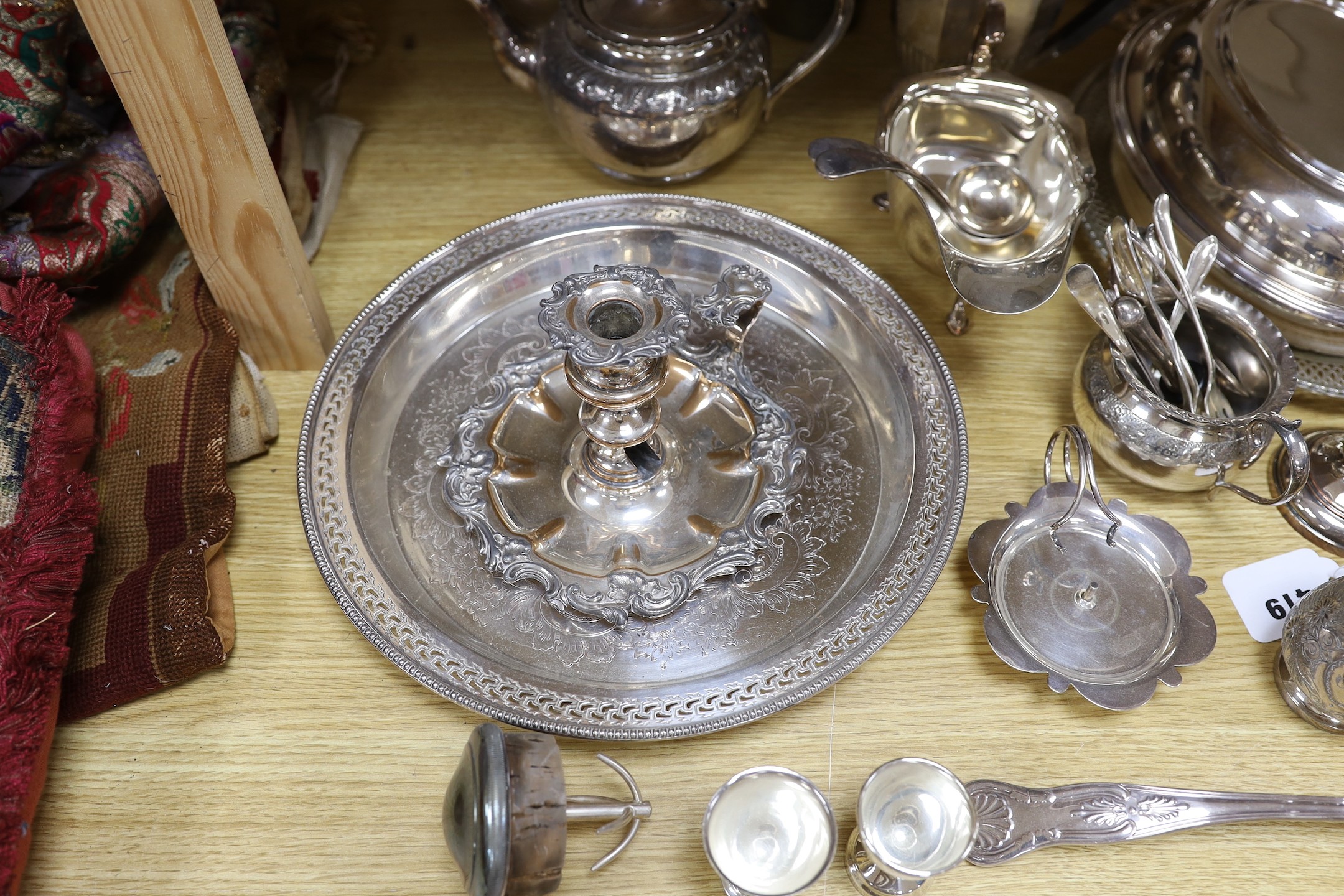 A quantity of assorted plated wares including a chamberstick, a tea set, flatware, a cocktail shaker, a sauceboat, goblets, etc.